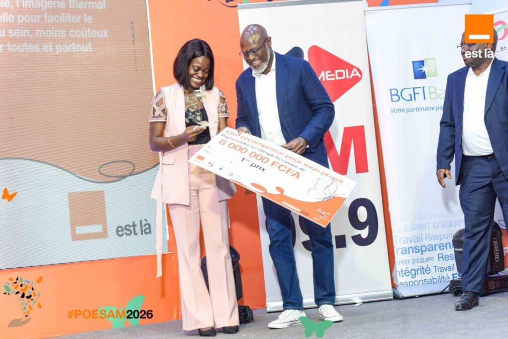 Juvis Anzia reçoit le premier prix du POESAM 2026 des mains de Patrick Benon, Directeur général de Orange Cameroun.
