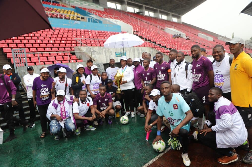 Rassemblement de la grande famille CCA-Bank autour du trophée ! Une photo de groupe pour immortaliser la cohésion et le succès sportif.