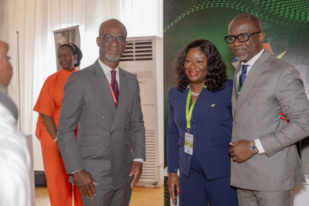 Groupe d'hommes et de femmes en tenue professionnelle échangeant des sourires lors de l'événement d'affaires.